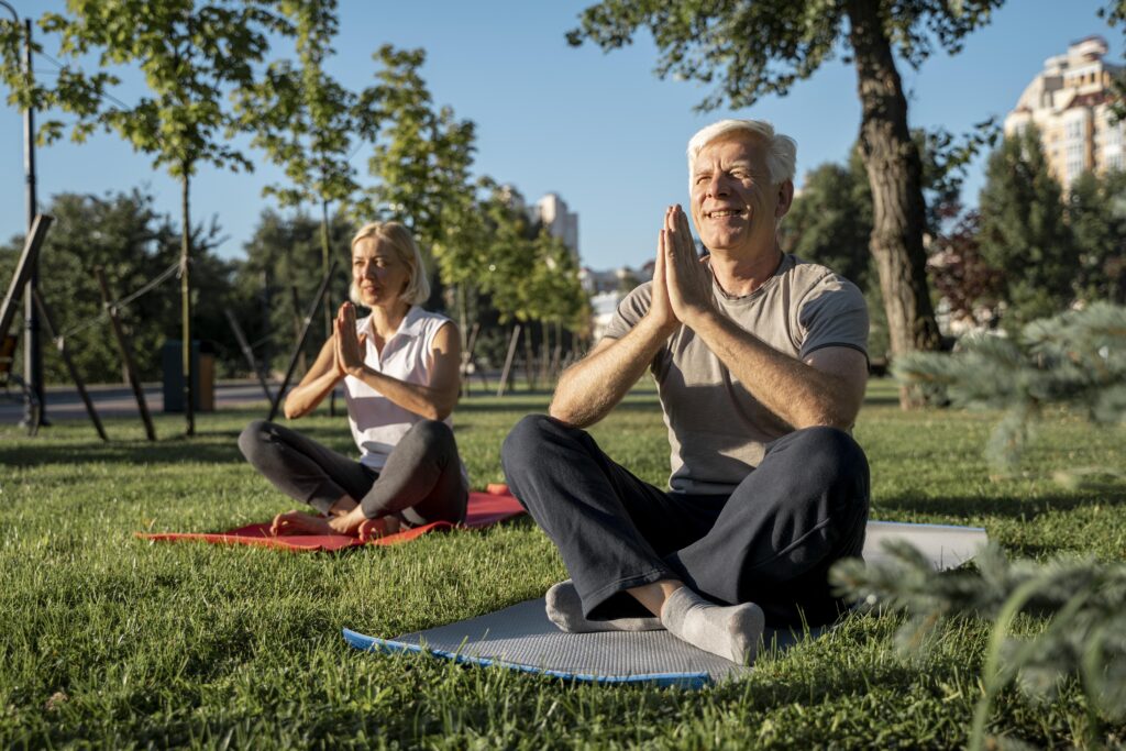 elder-couple-practicing-yoga-outside